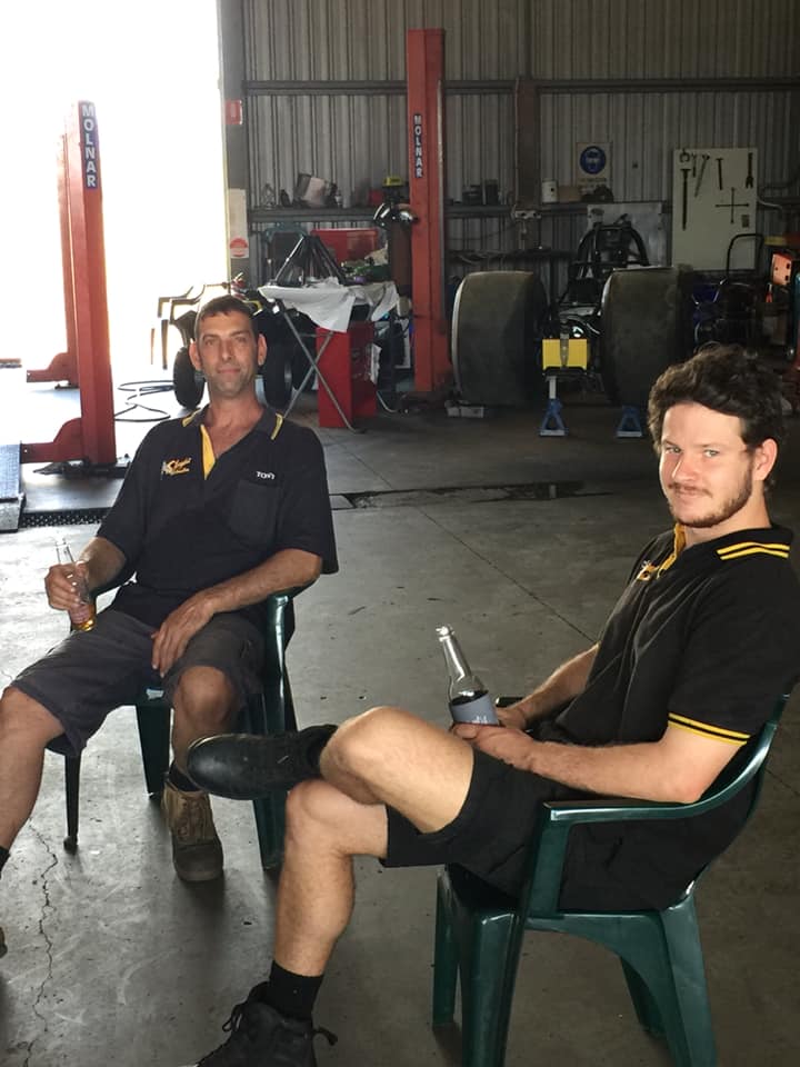 Two mechanics in Slingshot shirts taking a break in the workshop