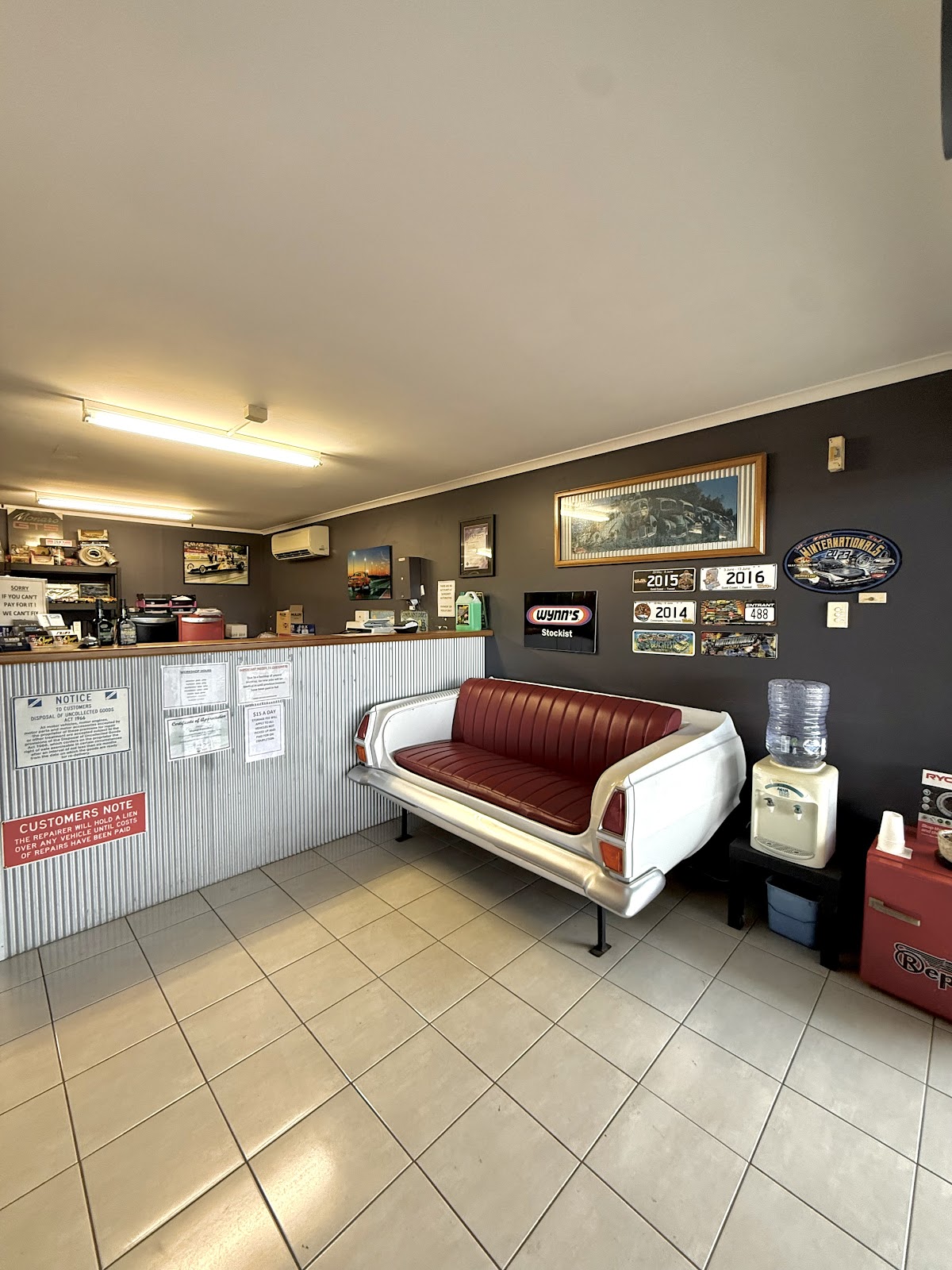 The reception at Slingshot Automotive, with a couch built from the back of a classic car and racing plates on the wall