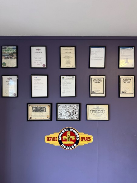 A wall of framed racing records and certificates in the office